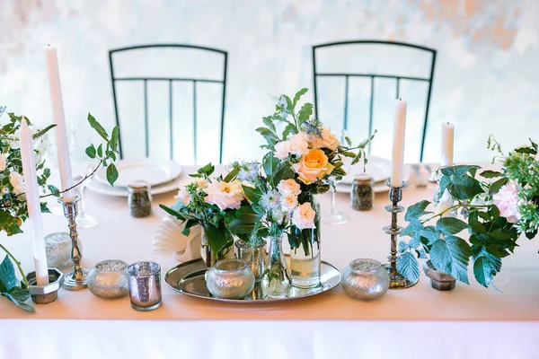 Alimentation, surprise, concept romantique. table de dîner décorée avec beaucoup de bougies dans les détenteurs de types et de nombres absolument différents de grappes avec des roses et d'autres fleurs délicates avec des bourgeons florissants — Photo
