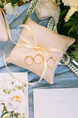 kavram düğün hediyesi, sürpriz. güzel top görüntülemek ince şerit ile küçük şeftali rengi yastık, üç altın yüzük üstünde o ve birkaç kartpostal resim gül ile yakın