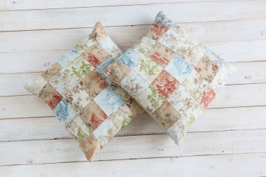 ev, dinlenme, hobi kavramı. birçok kare bölgeleri ve baskı üçlü, çiçekler ve evler için exsquisite baskı ile Yastık kılıfları iki plumpy rahat yastıklar oluşur