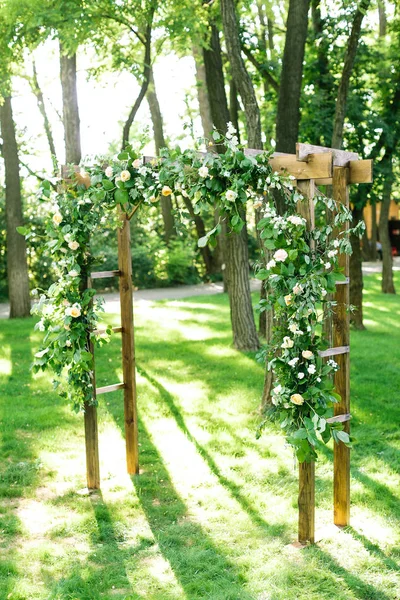 早上，庆祝，装饰概念。婚礼仪式拱装饰着白色的玫瑰和 carnationa 站在春初升的太阳温柔灯光 — 图库照片