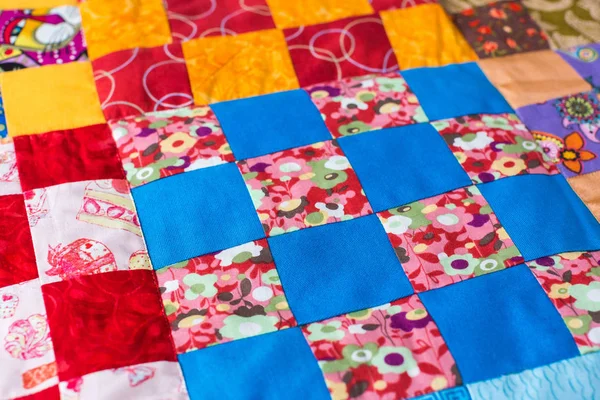 Homemade, interior, design, crafts, imagination, garment concept - multicolored textile field sewed of bright cotton squares with invisible stitches on the principle of mosaic — Stock Photo, Image