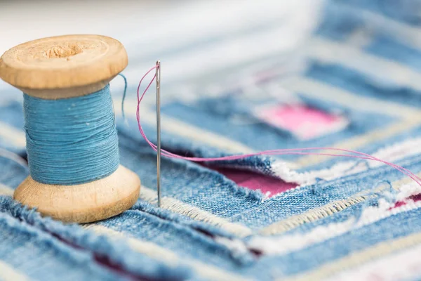 Costura e conceito de bordado - instalação de carretel de fios azuis e decorado com um tecido azul com padrão de corte, macro de costura e decoração de grife na forma de corte de labirinto em tecido . — Fotografia de Stock