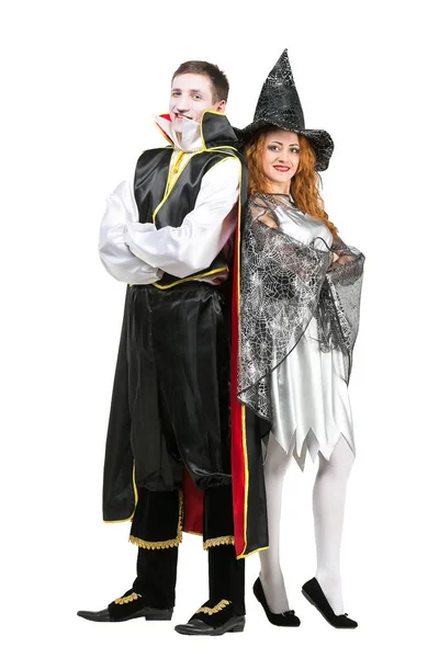 Costume party, dressing, entertainment concept. isolated couple of fairytale characters, vampire in black costume and witch in silver dress, they are smiling and standing back to back like superheroes — Stock Photo, Image