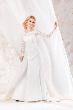 moda elbise, güzel sarışın model, düğün gelinlik kapalı açık renkli üzerinde duran genç kadın perdeleri poz sevimli kız gülümseyerek gelin saç ve makyaj kavram-.