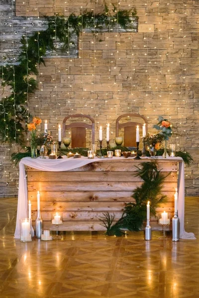 订婚, 庆祝, 盛宴的概念。新婚情侣的地方在 reastaurant 大厅, 装饰着无数的蜡烛和闪烁的灯光, 花卉和针叶树枝 — 图库照片