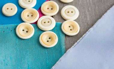 dikiş, patchwork, terzilik ve moda kavramı - makro sevimli beyaz giyim saçılma'tekstil kumaş, düz yatıyordu, en iyi görünümü mavi, gri, mor kanatlar üzerinde düğmeleri.