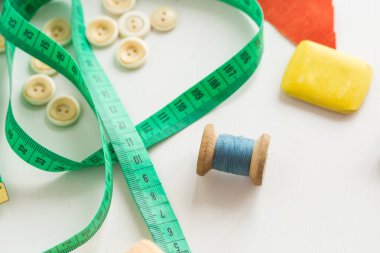 Iğne işi, dikiş ve kavram - makro beyaz giyim düğmeleri, sevimli yeşil metre, ölçme ile terzilik el sanatları, bobin iplik mavi ve beyaz arka plan, üstten görünüm, düz lay üzerinde kesim için sabun |.