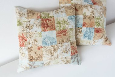 ev rahatlık, el sanatları, dikiş, patchwork kavramı - pastel tonları ile ihale çiçek baskılar ve kır evi görüntüsünü yamalari yapılan iki dekoratif yastık