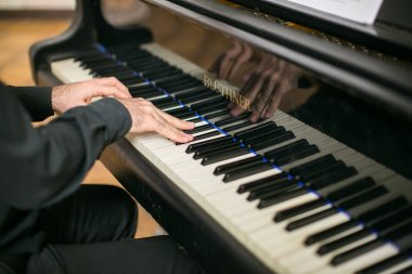 müzik, yetenek, konser kavramı. Harika vintage siyah piyano oynayan eski erkek silah hassas buruşuk uzun parmaklı ve düzenli manikür, yakın çekim
