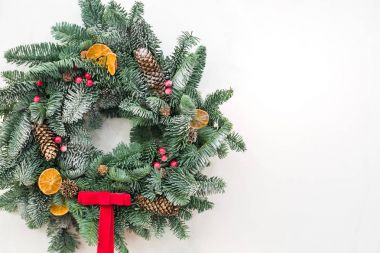 festivaller, tebrik, dekor kavramı. muhteşem Noel çelenk limon ve portakal, pinecones ve parlak kırmızı düzenli yay, metin için boş alan ile kurutulmuş dilimleri ile kozalaklı ağaç ve embelished yapılmış