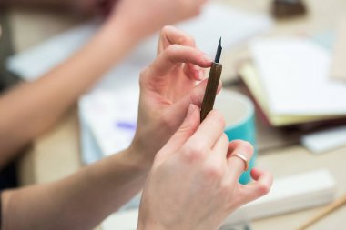 yaratıcılık, ekipman çizim, kavram handcrafting. derli toplu değil parlak manikür ve altın yüzük olan kadın sanatçı kollarında ahşap sahibi ile bir kalem olduğunu