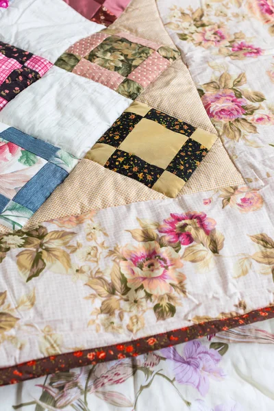 Huis, vintage, hobby concept. een ongelooflijke zelfgemaakte deken gemaakt van satine uitgevoerd in de stijl van een lappendeken met ornament hebben bloemblaadjes, planten en landschappen — Stockfoto