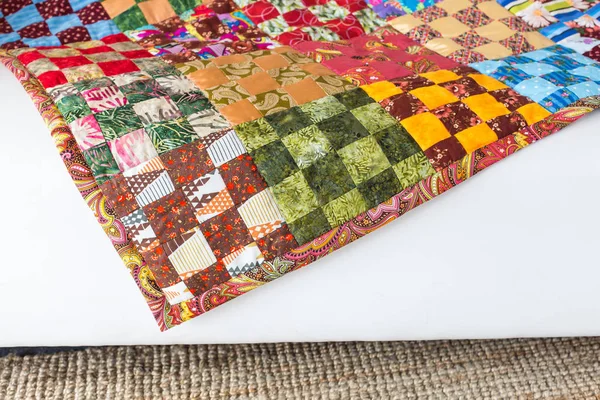 Шаблон, создание, украшение концепции. уютное теплое домашнее одеяло с красивой цветовой гаммой, изготовленное с использованием лоскутной текники, помещенной на мебель — стоковое фото