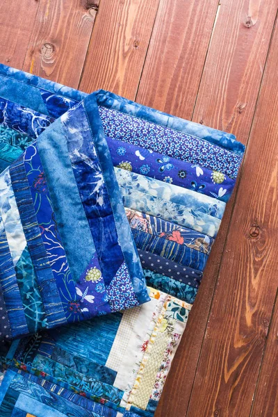 Rusten, coiziness, patchwork concept. gezicht- en onderzijde van zachtjes maded door handen blauw gekleurde badcover bevatte veel verschillende textiel schaafwonden en patronen — Stockfoto