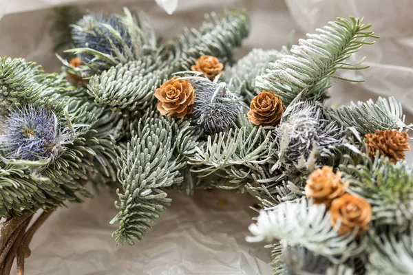 Eco friendly, decoração, conceito de ano novo. close up de ramos de coníferas verdes que teceram uns com os outros e flores inchadas lilás, neve coberta e decorada com minúsculas pinhas — Fotografia de Stock