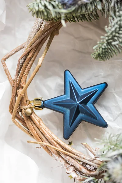 장식, 휴일, 새 해 개념입니다. 크리스마스의 상징의 놀라운 블루 스타, 하나, 그것은 황금 얇은 리본 및 작은 벨 유연한 나뭇가지에 묶여, 그들은 서로 함께 단단히 weaved 있습니다 — 스톡 사진
