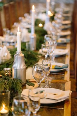 Doğa, çevre dostu, akşam yemeği konsepti. Tabak ve mum tutacağı olan bardakları kapatın. Yemekhanenin tüm ışıkları onlara yansıyor. Bu yüzden neredeyse parlıyorlar.