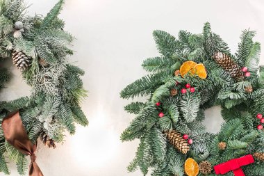 Dekorasyon, Yeniyıl, kış konsepti. bulanık kozalaklı ağaç dallarında şeritler ve fiyonk kırmızı meyveler ve pinecones ve hatta kurutulmuş meyveler ile düzenli çember içine dokunan