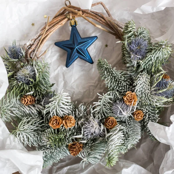 축 하, 휴일, 파티 개념입니다. 포장 용지에 가문비나무와 일부 라일락 공장, 그것의 정상 교수형은 블루 스타와 멋진 크리스마스 화 환 — 스톡 사진