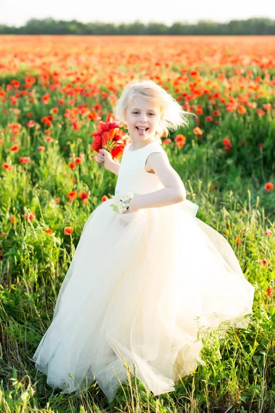 Girl model, poppies, wedding, fashion, children, nature and summer concept - elegant girl bridesmaid with white hair, teases, shows the language, play in a field of poppies, she in white wedding dress — Stock Photo, Image