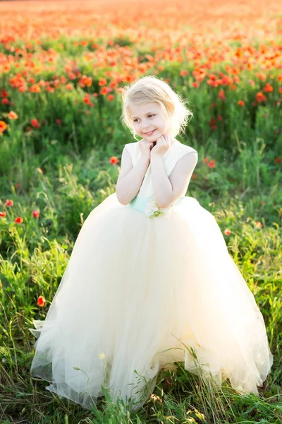 Girl model, poppies, wedding, fashion, children, nature and summer concept - elegant sweetheart girl bridesmaid with white hair flirts, plays in a field of poppies, she in a white wedding dress. — Stock Photo, Image