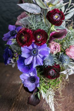 Bağlanma, doğal elementler, bitki konsepti. Anemonlar, bataryalar, güller ve zambaklar gibi renkli çiçeklerle profesyonel bir çiçekçi tarafından yaratılmış büyük ama sevimli bir düğün buketi değil.