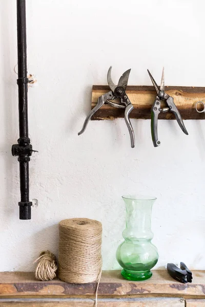 working, arts and crafts, supplies concept. there is a still life composed of equipment of workman on the white background of wall, there are pruners, rough twines and other stuff