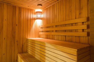 Sakin, iç mekan, eğlence konsepti. Buhar banyosunun hoş ve rahat bir arka planı var. Huzurlu bir ışık ve merdivene benzeyen ahşap banklar.