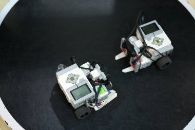 Robot teknolojisi, bilim, oyun konsepti. Popüler karikatür karakteri Walle 'a benzeyen yeni robotların üst görünümü, siyah yüzeye yerleştirilmiştir.