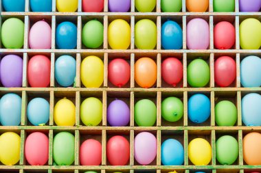 Eğlence, parti, eğlence konsepti. Popüler çekiciliğin renkli bir arka planı var ve raflarda bir sürü balonla meydan şeklinde yarışmalar yapılıyor.