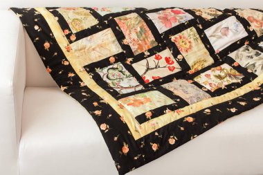 arka plan, iç mekan, dikiş konsepti. Kremalı kanepenin üzerinde birbirinden farklı kumaşlardan yapılmış harika bir el yapımı battaniye var.