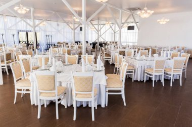 Dekor, resepsiyon, nişan partisi konsepti. Düğünü kutlamak için harika avizelerle aydınlatılmış bir yer var ve tüm mobilyalar beyaz ve şık.