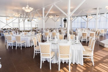 Yemek, mekan, iç mekan. Muhteşem ve büyük restoran salonu, pencerelerden gelen ışığın yanı sıra klasik tarzda harika avizelerle aydınlanıyor.