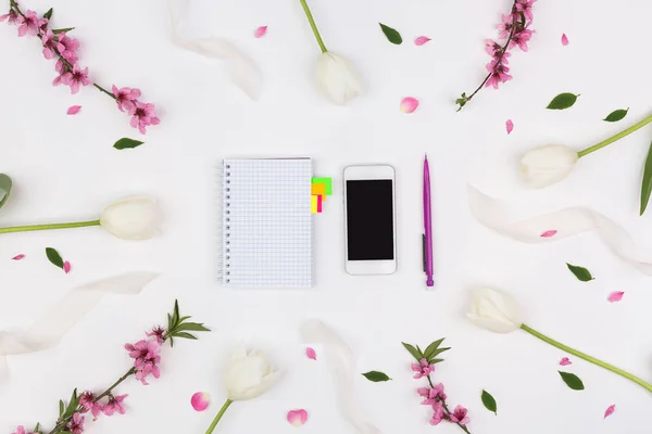 organisation, studding, fashion concept. tidy flat lay of must have things for businesswoman such as notebook and smartphone that are pleced in the frame of collected flowers
