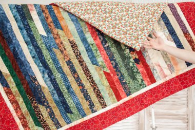 İç tasarım, konfor, ev yapımı konsept. Yıldızlar, yapraklar, ay ve güneş gibi çeşitli desenlere sahip kurdeleler gibi uzun örülmüş muhteşem yorganlar var.