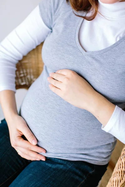 爱情的概念 紧紧抓住女人的肚子 她怀了九个月的孩子 不久她就要当妈妈了 她的胳膊温柔地搂着肚子 — 图库照片