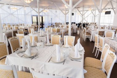 Yemek servisi, kutlama, parti konsepti. Restoran masalarında her biri için iki tabak gümüş çatal bıçak ve üç çeşit içki var.