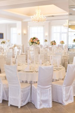 İç mekan, parti, düğün günü konsepti. Nişanı kutlamak için hazırlanmış bir restoran salonu var. Açık renklerle süslenmiş, tüm mobilyalar beyazdır.