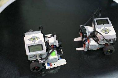Makine, elektronik, teknolojik yenileme konsepti. Birbirine bakan iki küçük robotun bir sürü kablosu, tekerlek çiftleri ve küçük ekranları var.