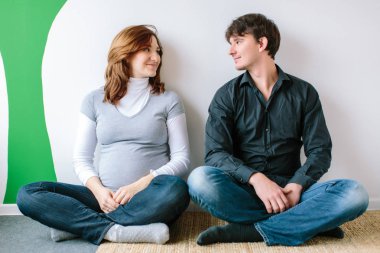 Güzellik, aşk, aile kavramı. Sevgili, bir bebek bekliyor yeni aile, bir çift, lotus pozisyonunda katta oturan ve birbirlerine arıyoruz