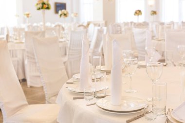 Yemek, parti, düğün kavramı. parlayan plakaları yakın çekim ve şarap gözlük, bir sürü Bulaşık sırası yerleştirilir beyaz peçeteler, neredeyse tüm salonu ile karışık