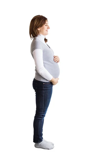 Embarazo, maternidad, concepto futuro. hay una figura aislada de mujer joven y hermosa embarazada, ella está brillando con alegría y sonriendo, abrazando su vientre — Foto de Stock