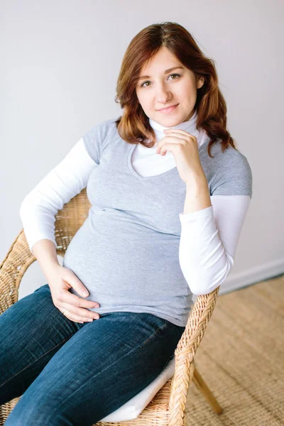 Stile di vita, parto, concetto di tenerezza. c'è una donna sorridente con un bel taglio di capelli e begli occhi, aspetta un bambino presto e vestito in modo speciale per le madri — Foto Stock