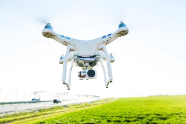 Rusya, Rostov-On-Don-20 Nisan 2017: quadrocopter kalkış, düşük üzerinde beyaz drone ile kurmak-içinde fotoğraf makinesi arka plan yaz çim sahası, yol ve mavi gökyüzü, önden görünüm, uçan