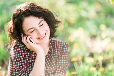Güzellik, iletişim, teknoloji konsepti. Elinde akıllı telefonlu bir iş kadını portresi var. Parlak bir makyajı ve güzel bir gülümsemesi yok.