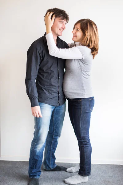 Felicità, armonia, concetto di relazioni. c'è felice coppia appena sposata, lei è incinta, e suo marito la sta delicatamente abbracciando con una mano — Foto Stock