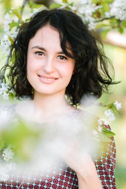 çevre, yürüyüş, yaşam kavramı. elma ve kiraz çiçekleri çiçek gördüğünüz ağaçlar düşünce güzel kadın parlak gözleri ve nazik bir gülümseme ile o çok doğal görünüyor