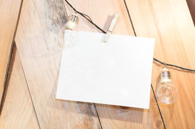 Kutlama, parti, tebrik konsepti. Parlak ışıkların arasında tahtanın kaba ahşap yüzeyinde siyah kabloya atanmış beyaz bir tebrik kartı var.