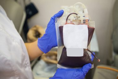 Hemşirelerin yakın çekimleri, ellerinde kan dolu plastik torbalar olan tek kullanımlık koruyucu eldivenler veriyor..