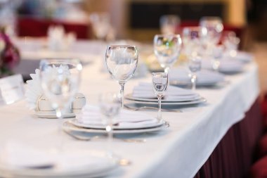 Beyaz şarap kadehleri ve içki kadehleriyle masa ayarları. Düğün dekoru, restoran düzeni..